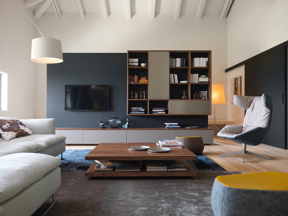 На фото: гостиная комната в современном стиле с белыми стенами, светлым паркетным полом и телевизором на стене с