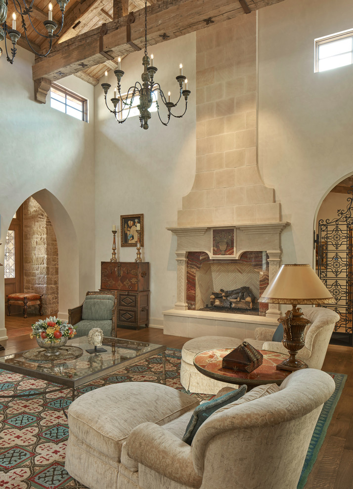 Foto de salón mediterráneo extra grande con paredes beige y marco de chimenea de piedra