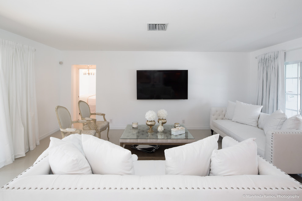 Modelo de salón cerrado marinero con paredes blancas, suelo de baldosas de cerámica, televisor colgado en la pared y suelo beige