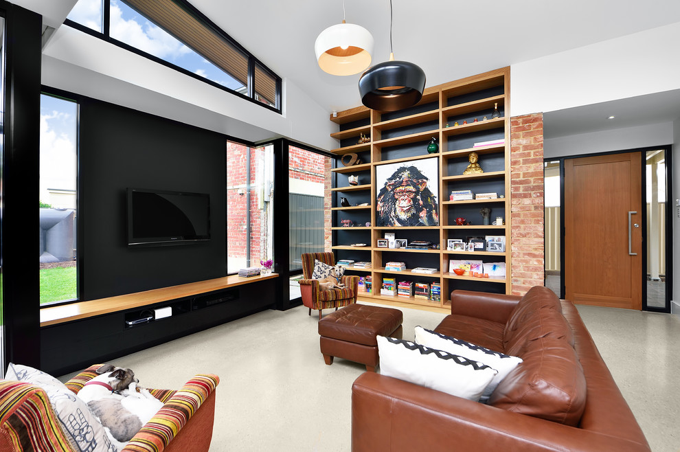 Стильный дизайн: гостиная комната в современном стиле с телевизором на стене, белыми стенами и бетонным полом - последний тренд