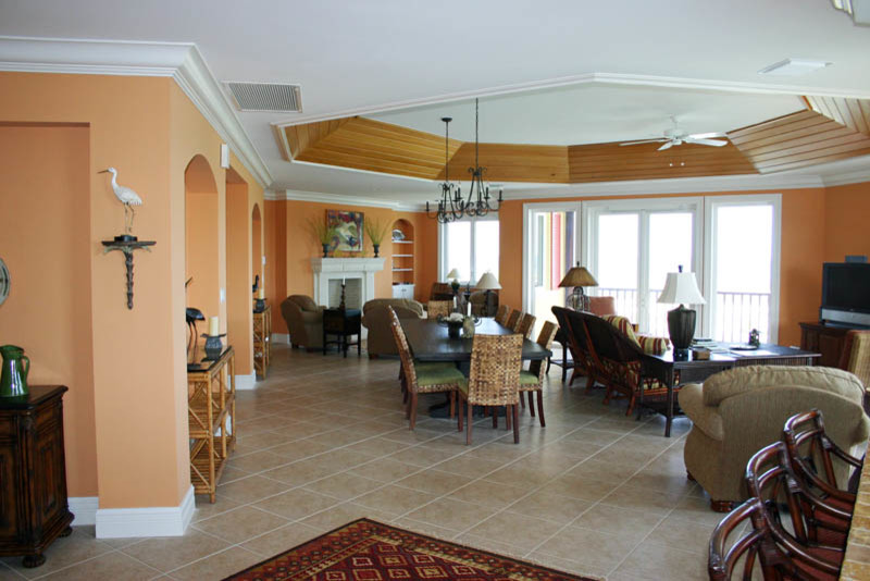 Idée de décoration pour un très grand salon ethnique ouvert avec une salle de réception, un sol en carrelage de céramique, une cheminée standard, un manteau de cheminée en pierre, un téléviseur indépendant et un mur orange.