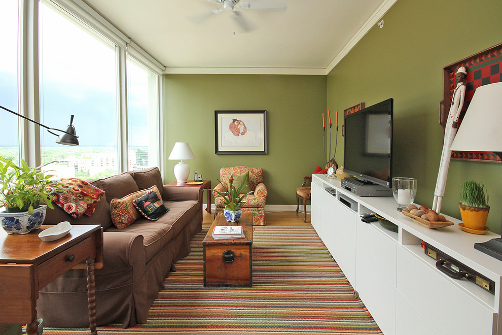Пример оригинального дизайна: гостиная комната в стиле фьюжн с зелеными стенами, отдельно стоящим телевизором и ковром на полу