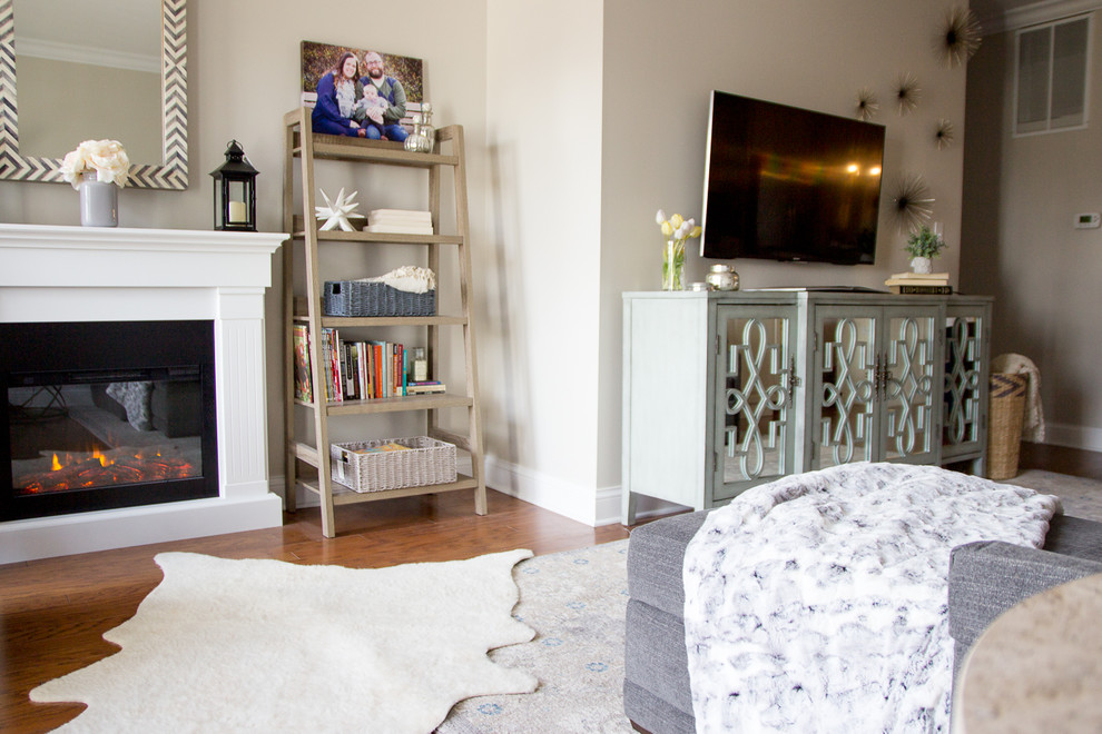 Immagine di un piccolo soggiorno chiuso con libreria, pavimento in legno massello medio, TV a parete e pavimento marrone