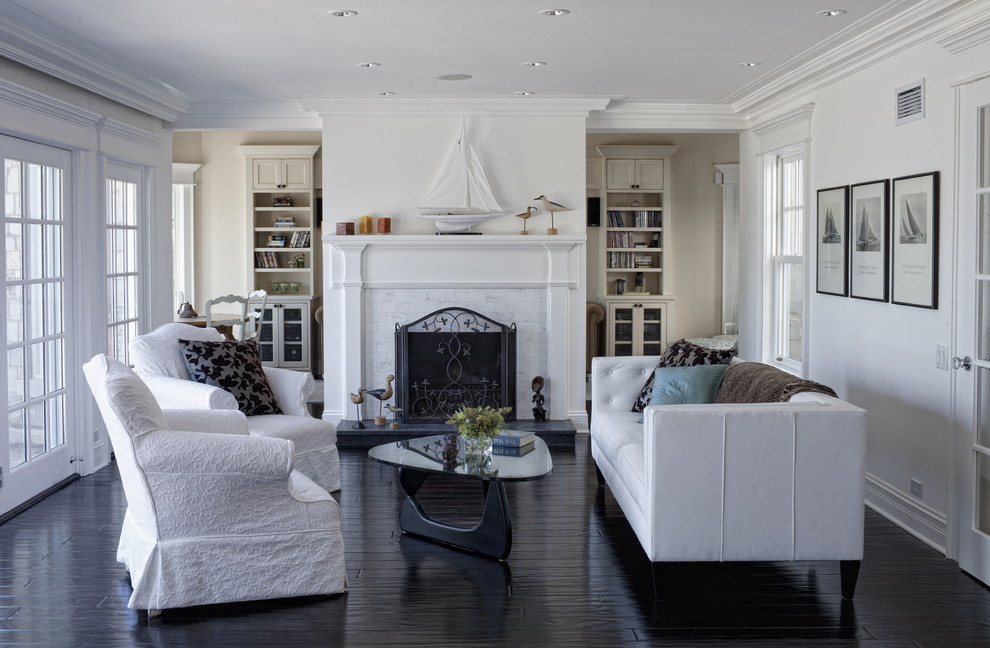 Immagine di un soggiorno chic con pareti bianche, camino classico, nessuna TV e pavimento nero