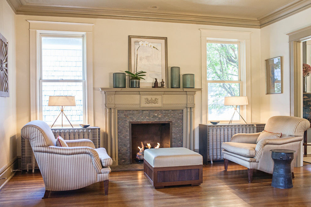 Idée de décoration pour un salon tradition de taille moyenne et fermé avec une salle de réception, un mur beige, un sol en bois brun, une cheminée standard, un manteau de cheminée en carrelage et un sol marron.