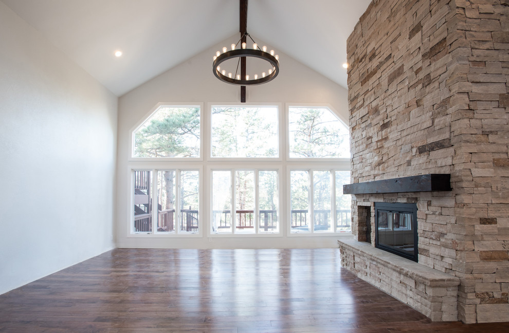 This is an example of a medium sized contemporary formal mezzanine living room in Denver with beige walls, medium hardwood flooring, a standard fireplace, a stone fireplace surround and no tv.