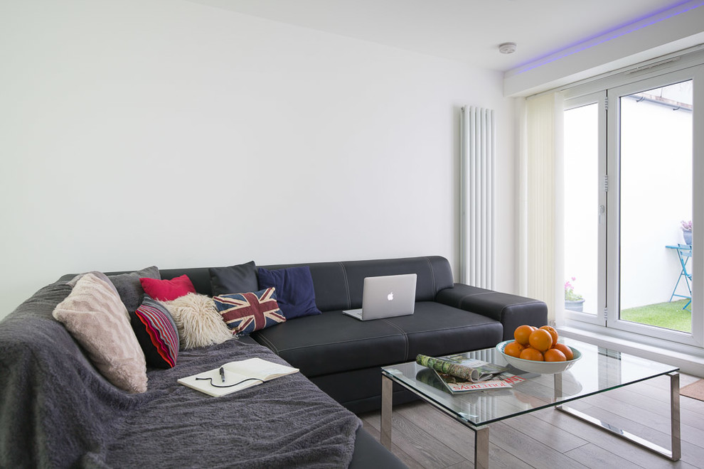 Idee per un piccolo soggiorno minimalista aperto con pareti bianche e parquet chiaro