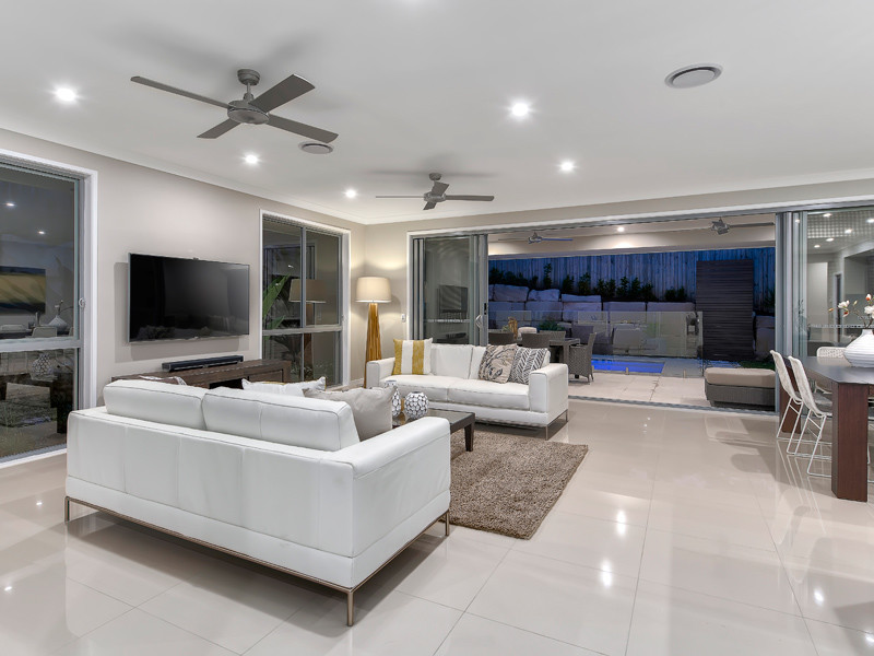 На фото: открытая гостиная комната среднего размера в современном стиле с серыми стенами, полом из керамической плитки и телевизором на стене без камина