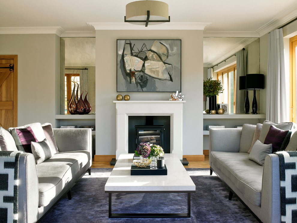 Идея дизайна: парадная, открытая гостиная комната в стиле неоклассика (современная классика) с серыми стенами и стандартным камином