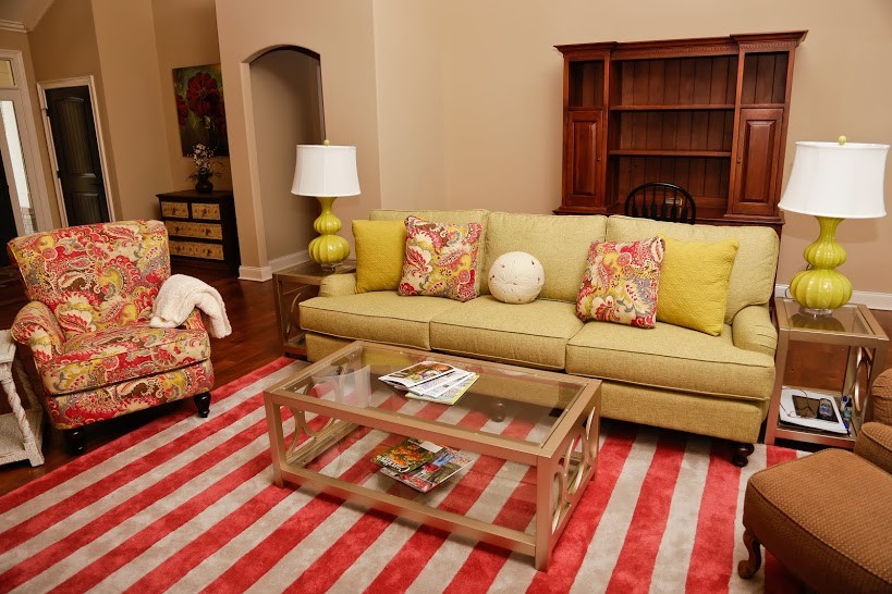 Modelo de salón abierto tradicional grande con paredes beige y suelo de madera en tonos medios