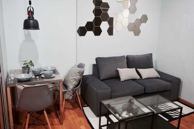 Bild på ett litet industriellt separat vardagsrum, med ett finrum, grå väggar, laminatgolv, en fristående TV och brunt golv