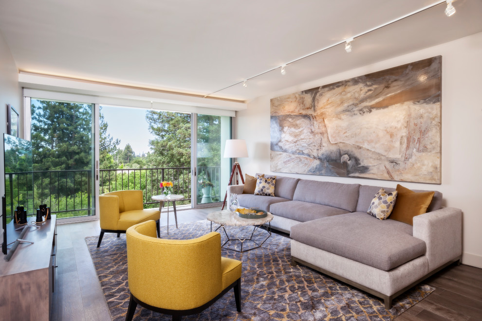 Foto di un soggiorno moderno di medie dimensioni e aperto con pareti beige, parquet scuro, nessun camino, TV autoportante e pavimento marrone