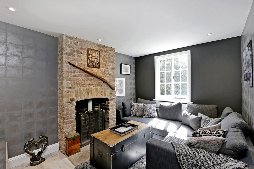Klassisches Wohnzimmer mit grauer Wandfarbe, hellem Holzboden, Kamin und Kaminumrandung aus Backstein in Hertfordshire