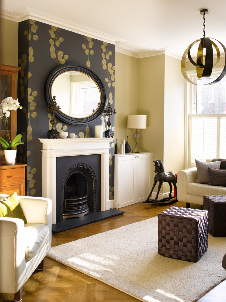 Inspiration for a large classic formal living room in London with a standard fireplace, no tv, medium hardwood flooring, beige walls and feature lighting.