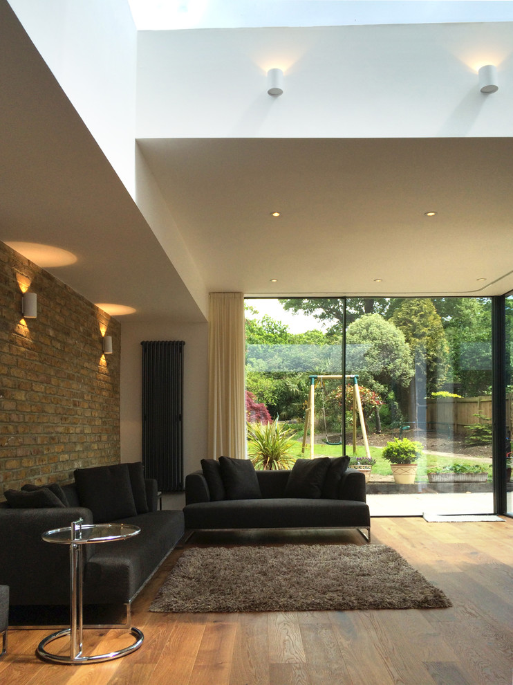 Offenes Modernes Wohnzimmer mit braunem Holzboden in London