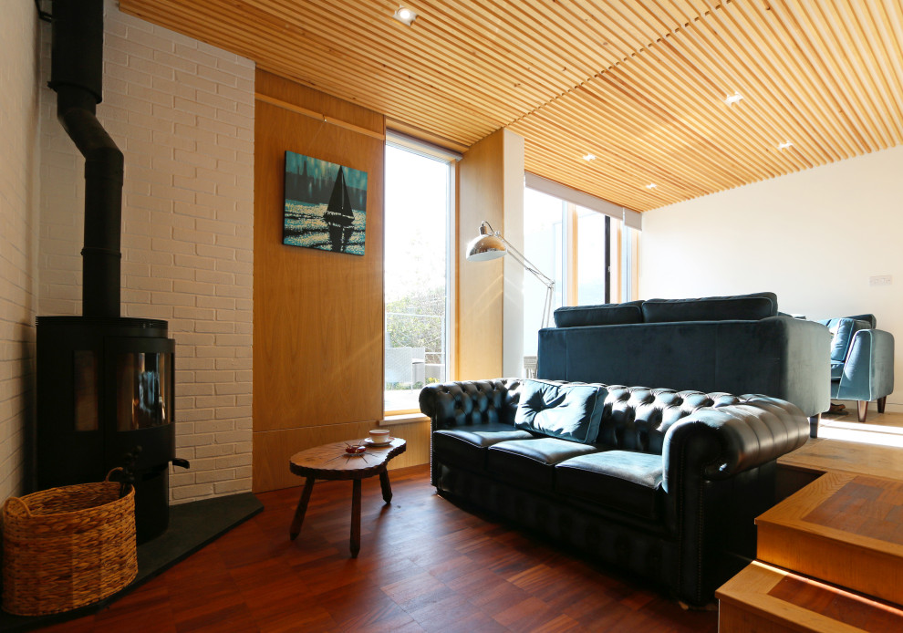 Mittelgroßes, Offenes Retro Wohnzimmer mit Kaminofen, Holzdielendecke und Wandpaneelen in Devon