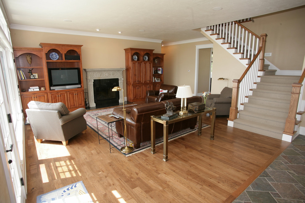 Esempio di un soggiorno chic aperto con pareti beige, pavimento in legno massello medio e camino classico