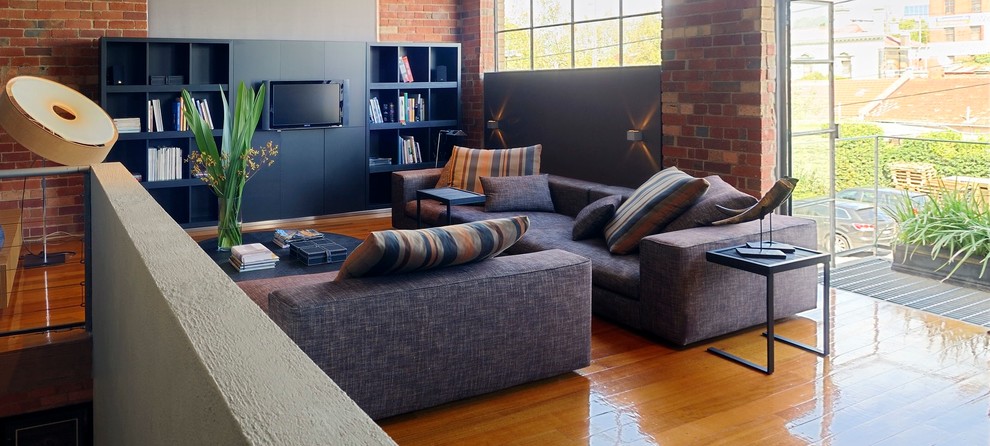 Idee per un grande soggiorno minimal stile loft con parete attrezzata e pavimento in legno massello medio