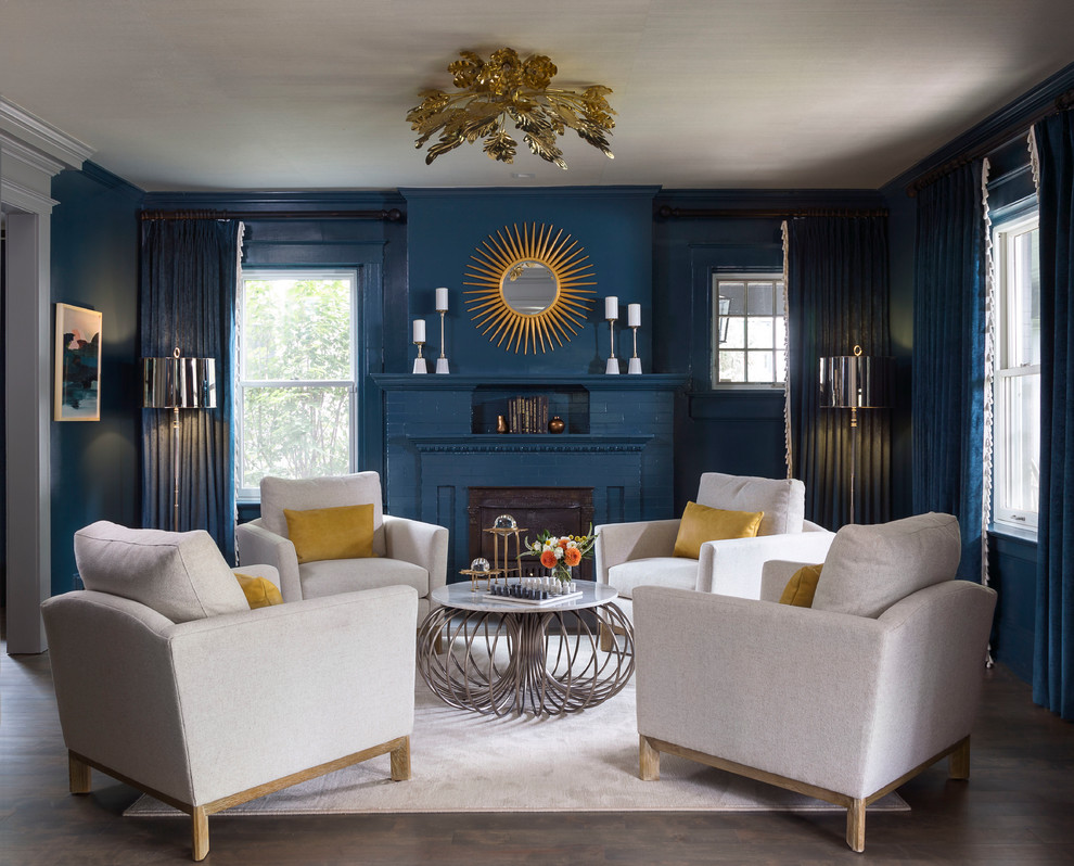 На фото: парадная, изолированная гостиная комната среднего размера в стиле неоклассика (современная классика) с синими стенами, темным паркетным полом, стандартным камином, синими шторами и ковром на полу без телевизора
