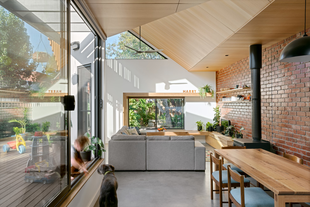 Inspiration for a mid-sized contemporary open concept concrete floor and gray floor living room remodel in Melbourne with white walls, a wood stove and a tv stand