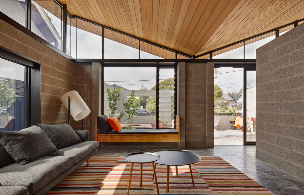 Immagine di un soggiorno minimalista aperto con sala formale, pareti grigie e pavimento in cemento