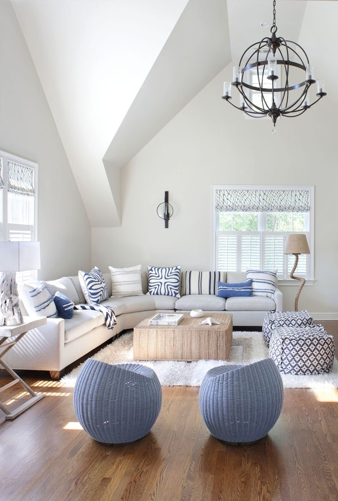 Beach style medium tone wood floor and brown floor living room photo in New York with white walls