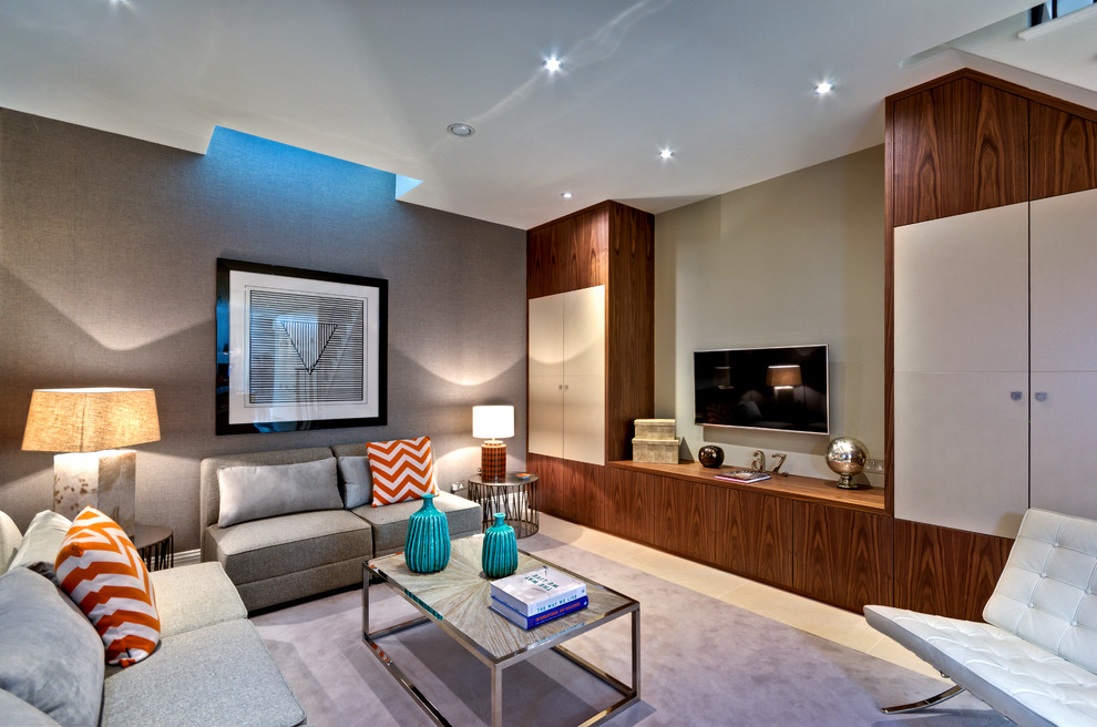 Modelo de salón cerrado moderno de tamaño medio con paredes grises, televisor colgado en la pared y suelo beige