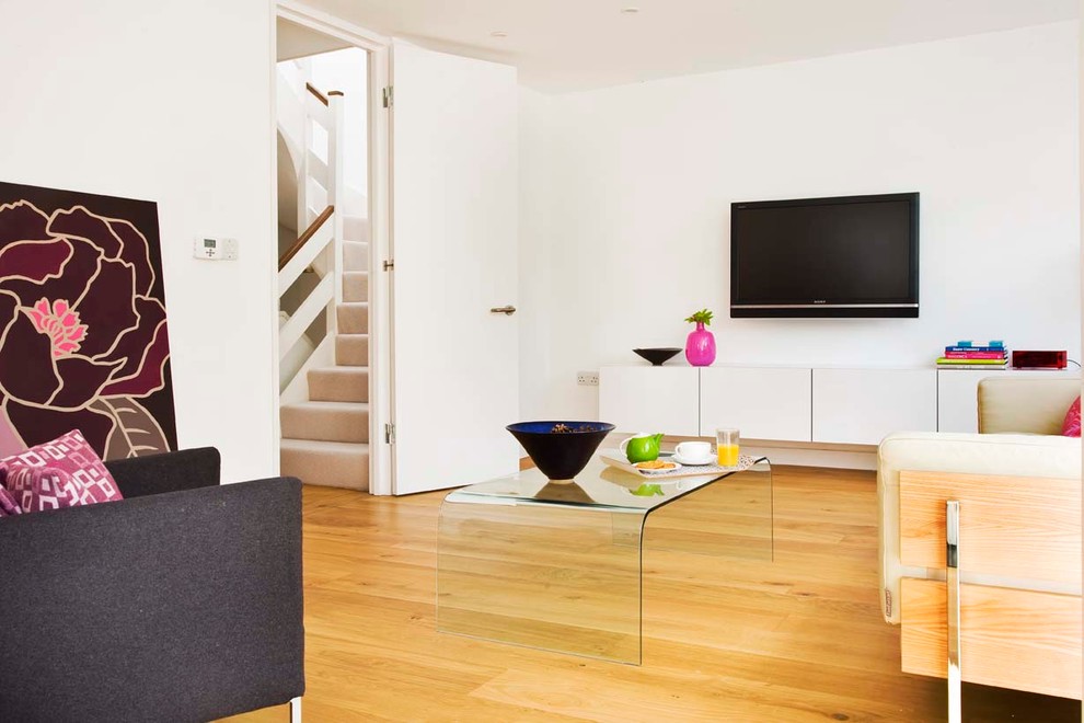 Mittelgroßes, Repräsentatives, Offenes Modernes Wohnzimmer mit weißer Wandfarbe, braunem Holzboden, Kaminofen, Kaminumrandung aus Metall und TV-Wand in Surrey