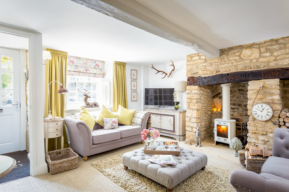 Inspiration for a large rustic formal and enclosed carpeted living room remodel in Gloucestershire with white walls, a wood stove, a stone fireplace and a tv stand