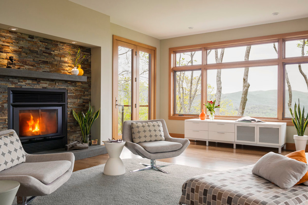 Esempio di un soggiorno design con pareti beige, pavimento in legno massello medio e camino classico