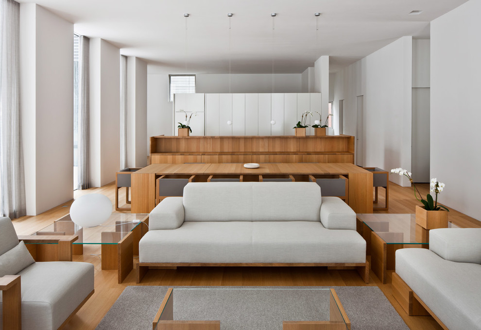 Diseño de salón para visitas abierto contemporáneo de tamaño medio con paredes blancas y suelo de madera en tonos medios