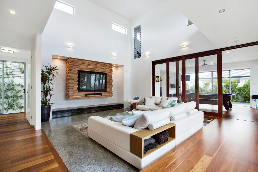 Großes, Offenes Modernes Wohnzimmer mit weißer Wandfarbe, Betonboden, Kamin, gefliester Kaminumrandung und Multimediawand in Gold Coast - Tweed
