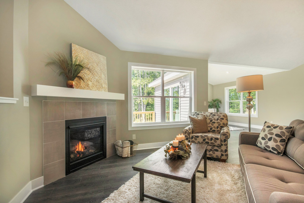 Photo of a medium sized contemporary living room in Grand Rapids with grey walls, laminate floors, a hanging fireplace, a tiled fireplace surround and brown floors.