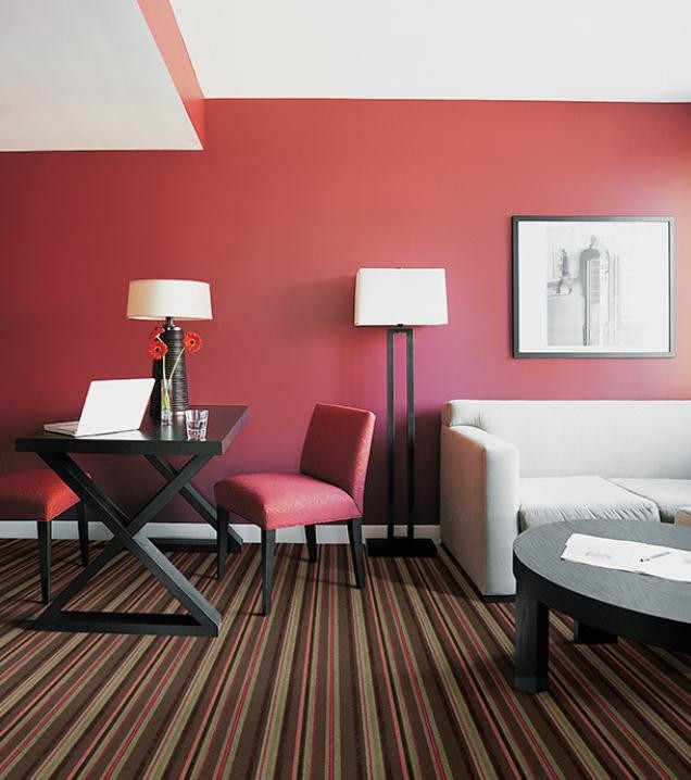 Foto de salón moderno de tamaño medio con paredes rojas, moqueta y suelo multicolor