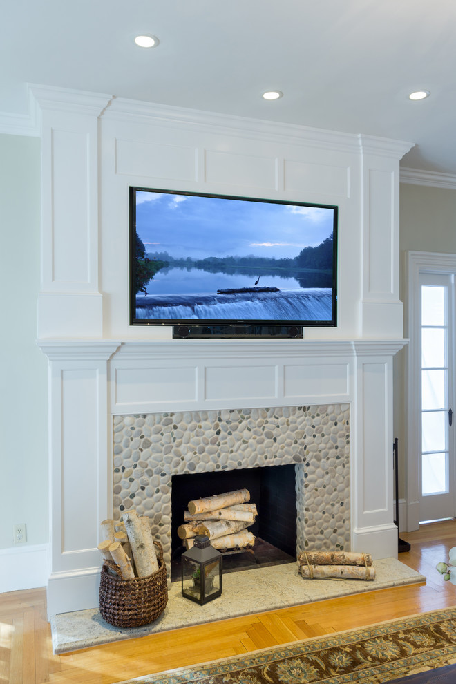 На фото: большая изолированная гостиная комната в классическом стиле с телевизором на стене, бежевыми стенами, светлым паркетным полом, стандартным камином и фасадом камина из дерева с