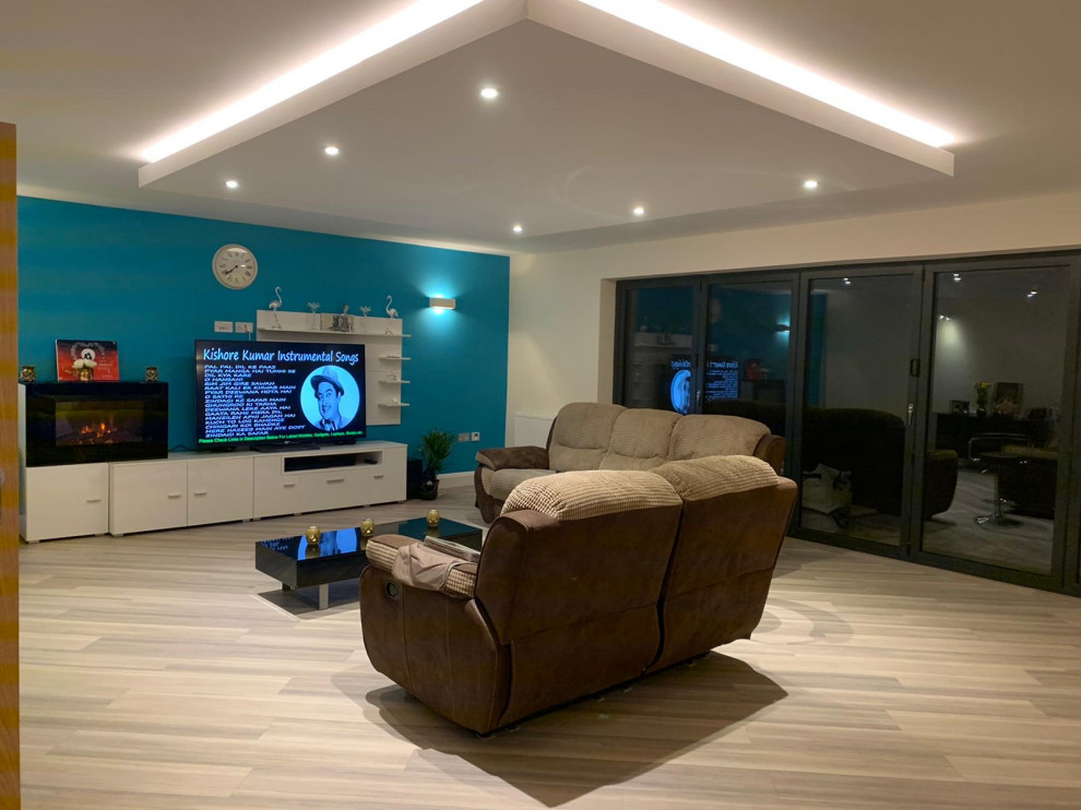 Immagine di un soggiorno minimal di medie dimensioni e aperto con sala formale, pareti verdi, pavimento in vinile, TV autoportante, pavimento grigio e soffitto ribassato