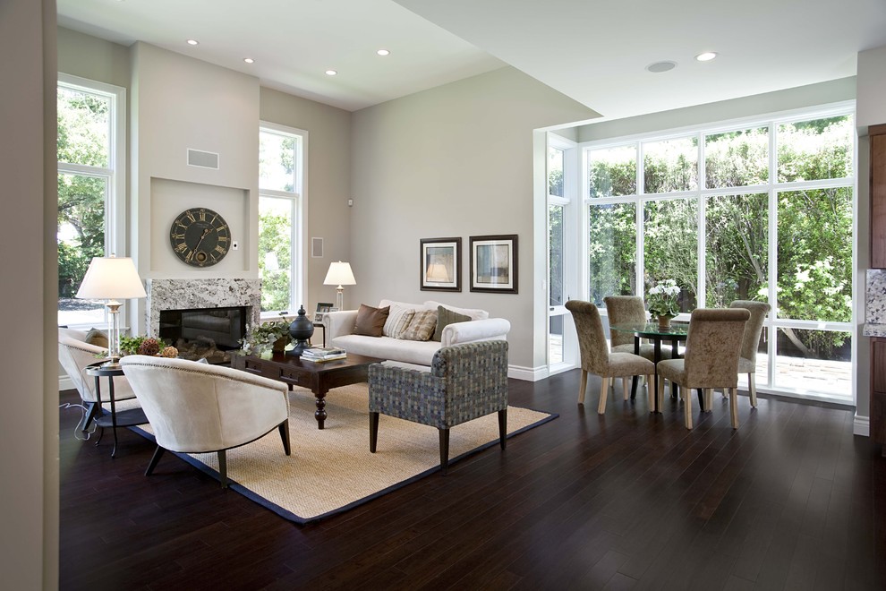 Inspiration for a contemporary open plan living room in San Francisco with grey walls, dark hardwood flooring, a standard fireplace, a stone fireplace surround, no tv, brown floors and feature lighting.
