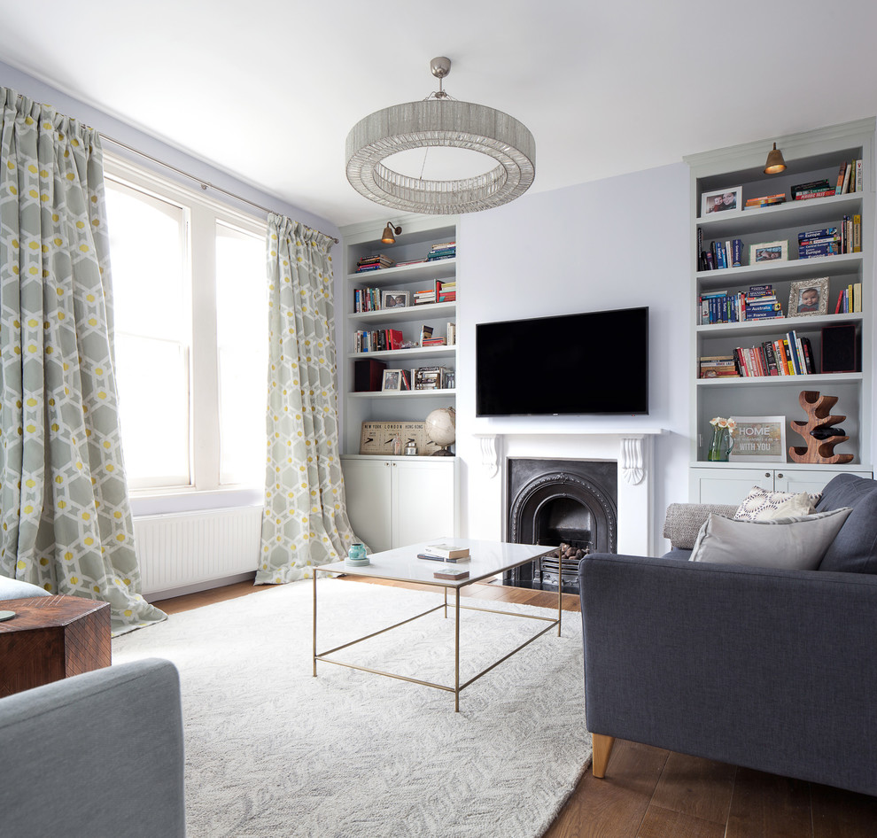 Mittelgroßes, Abgetrenntes Modernes Wohnzimmer mit blauer Wandfarbe, braunem Holzboden, Kamin, Kaminumrandung aus Stein, TV-Wand und braunem Boden in London