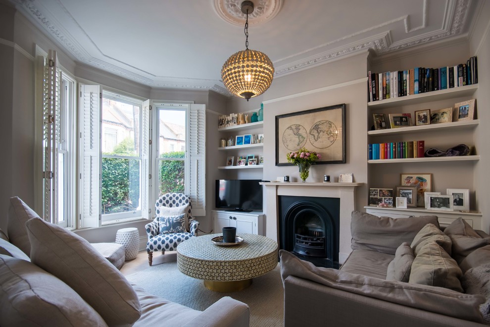 Mittelgroßes, Abgetrenntes Klassisches Wohnzimmer mit brauner Wandfarbe, Kamin, Kaminumrandung aus Metall und freistehendem TV in London
