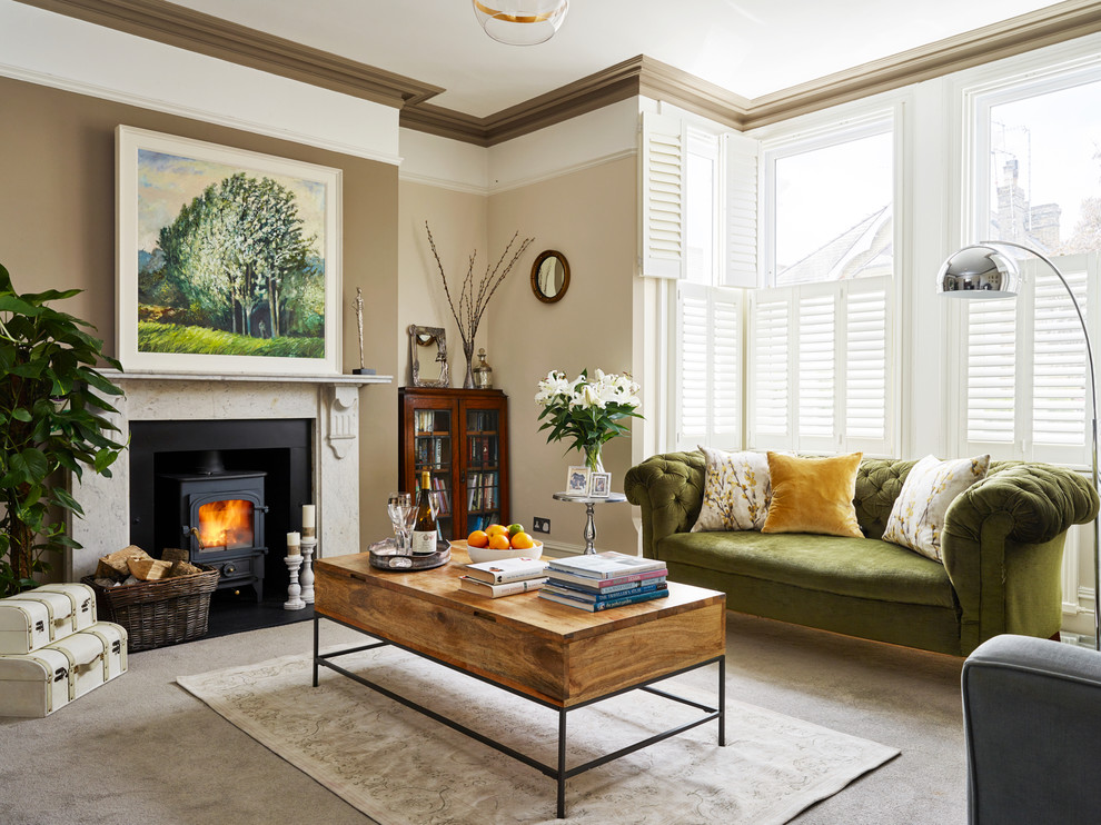 Foto di un soggiorno chic di medie dimensioni con pareti beige, moquette, stufa a legna, cornice del camino in pietra e pavimento grigio