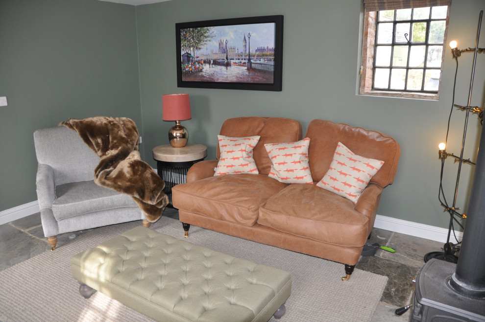 Foto di un piccolo soggiorno chic chiuso con sala formale, pareti verdi, pavimento in ardesia, stufa a legna, TV a parete e pavimento grigio