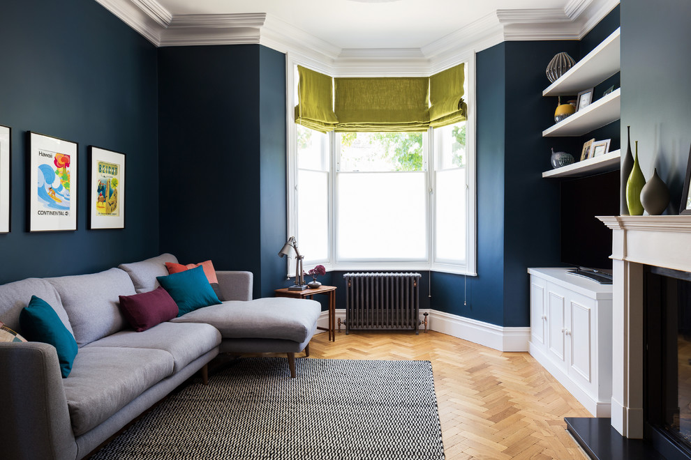 Idée de décoration pour un salon design avec un mur bleu et parquet clair.