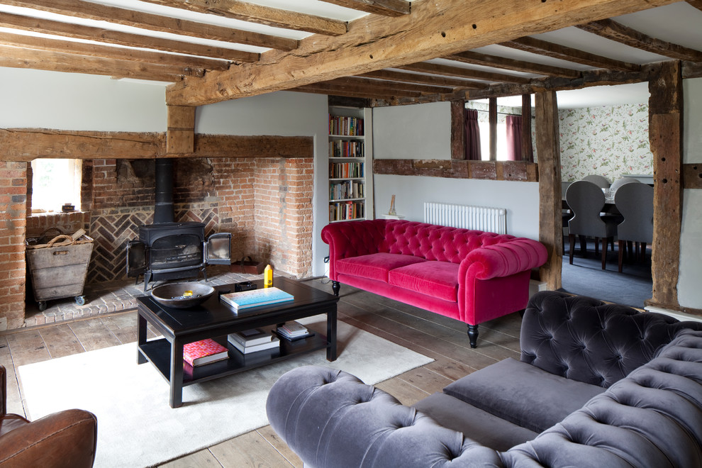 Imagen de salón para visitas campestre con paredes blancas, estufa de leña y suelo de madera clara