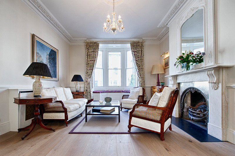Inspiration for a medium sized traditional formal open plan living room in London with white walls, medium hardwood flooring, a standard fireplace, a stone fireplace surround and no tv.
