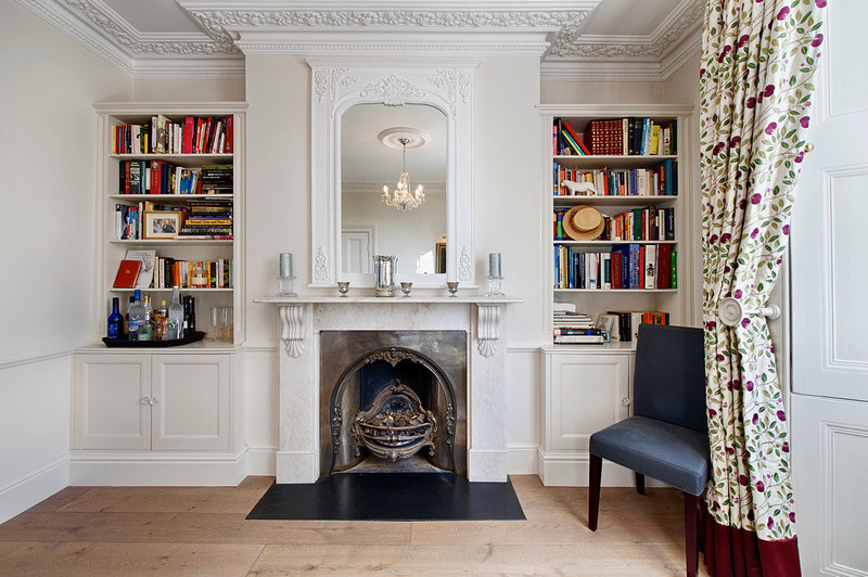 Photo of a medium sized traditional formal open plan living room in London with white walls, medium hardwood flooring, a standard fireplace, a stone fireplace surround and no tv.