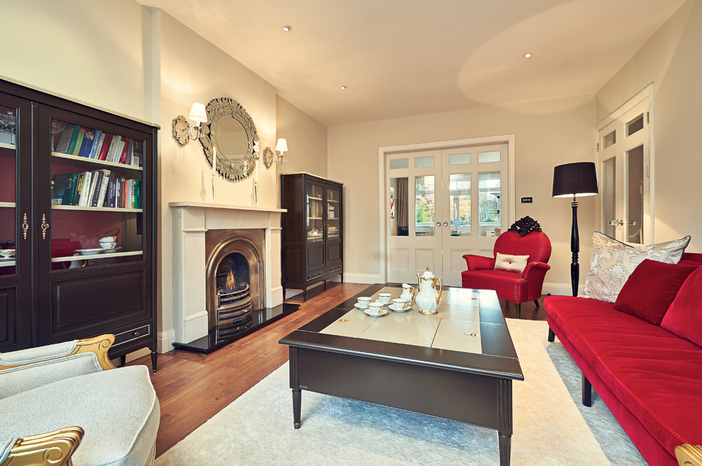 Mid-sized eclectic formal and open concept medium tone wood floor living room photo in London with white walls, a standard fireplace, a wood fireplace surround and no tv