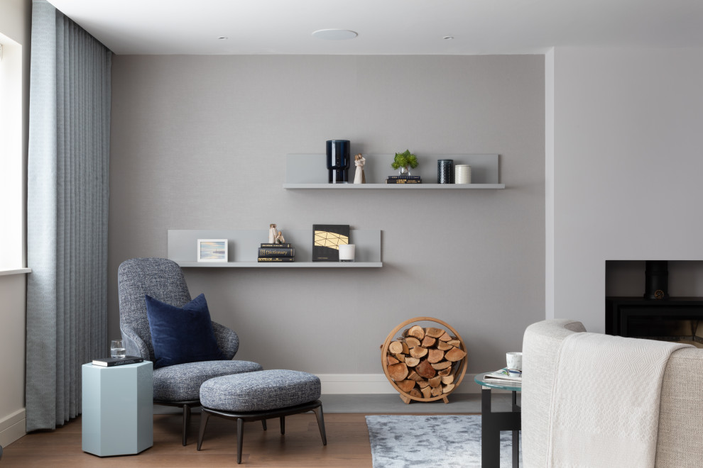 Inspiration for a large contemporary formal open plan living room in Hertfordshire with beige walls, dark hardwood flooring, a wood burning stove, a plastered fireplace surround and a wall mounted tv.