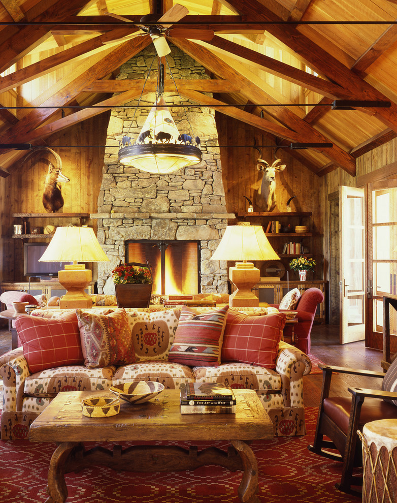 Idée de décoration pour un salon chalet avec une cheminée standard, un manteau de cheminée en pierre et éclairage.