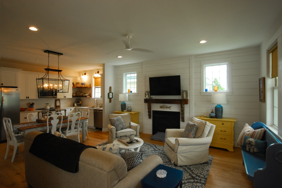 Mid-sized beach style enclosed wood ceiling, brown floor and shiplap wall living room photo with white walls, a wall-mounted tv, a standard fireplace and a shiplap fireplace
