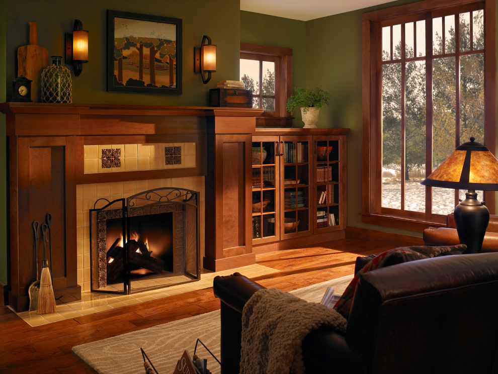 Inspiration for a mid-sized craftsman open concept medium tone wood floor living room library remodel in Other with green walls, a standard fireplace, a tile fireplace and no tv